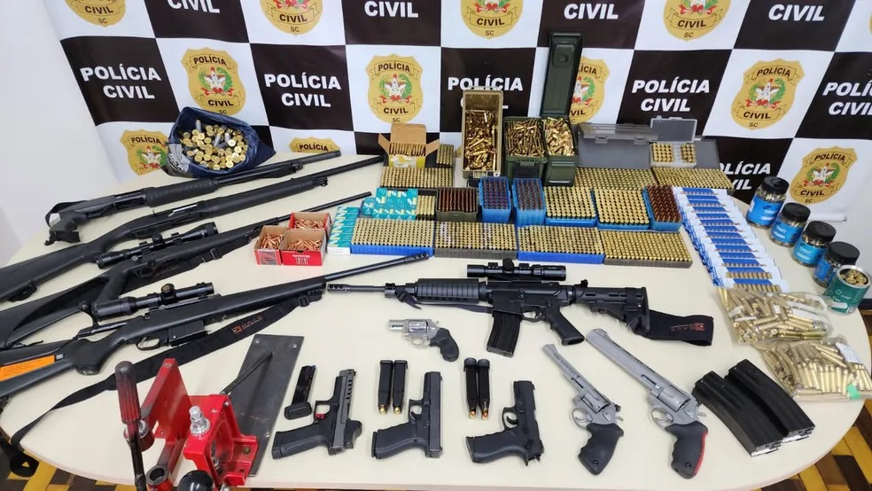 Dupla com envolvimento em bloqueio ilegal em SC é presa com 11 armas, incluindo fuzis, e R$ 125 mil